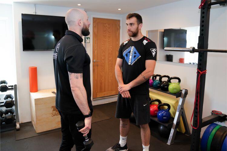 Dale Hardiman assessing an athlete in the clinic gym at Hardiman Performance
