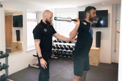 Coached barbell rehabilitation in the clinic gym at Hardiman Performance