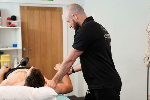 Hands-on osteopathic treatment on the plinth at Hardiman Performance